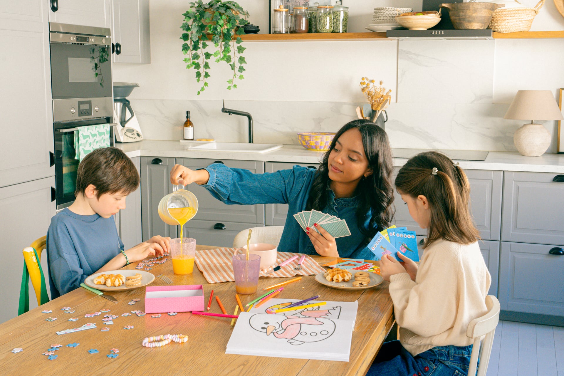 Une nounou qui s'occupe de 2 enfants dans une cuisine