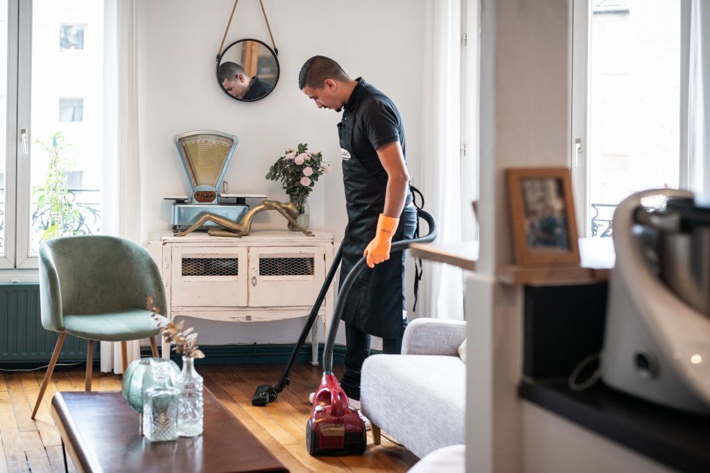 homme de menage passe aspirateur salon