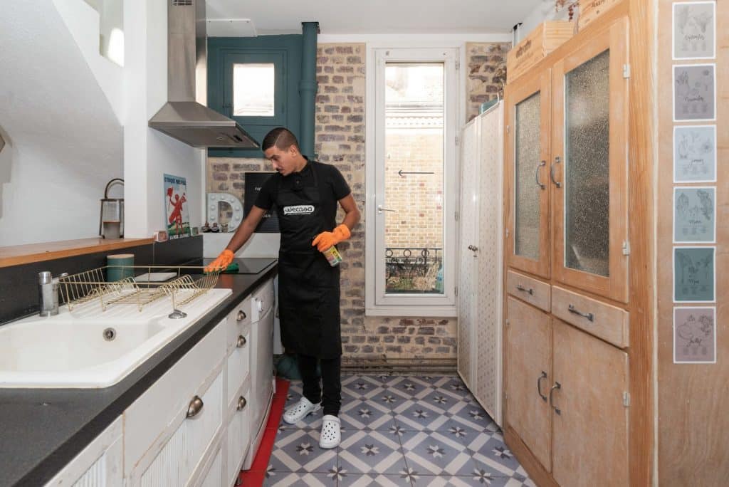 image d un homme de menage nettoyant la cuisine avant la vente de la maison