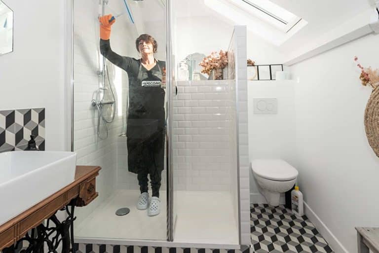 image d'une femme de menage nettoyant une cabine de douche