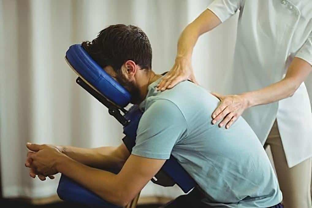 Homme étant massé sur un fauteuil de massage