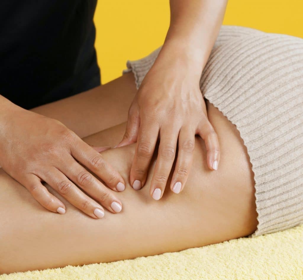 Une femme reçoit un massage anti-cellulite palper rouler sur les cuisses