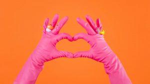 Femme de ménage faisant un coeur avec ses gants de ménage - tarif femme de ménage