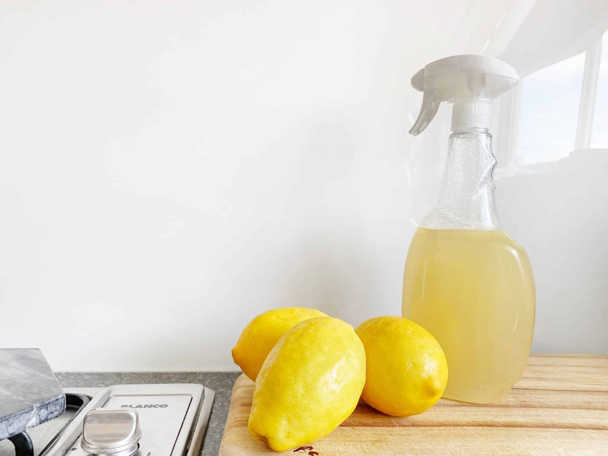 Des produits de nettoyage et du citron à côté d'une plaque de cuisson.