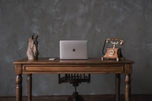 un bureau vintage en bois avec un macbook dessu