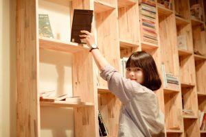 une femme qui prend un livre de la bibliothèque