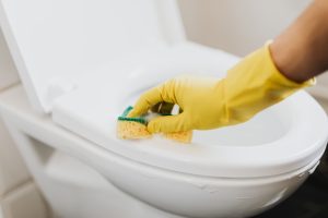 une main qui nettoie des toilettes