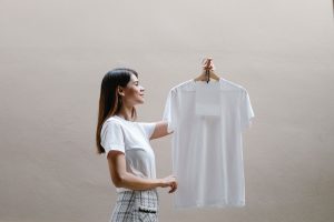 une femme qui tient un t-shirt blanc