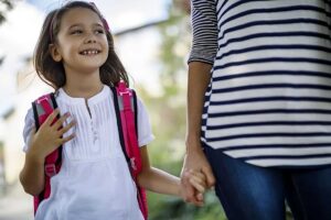 une nounou ramène une petite fille de l'école jusqu'à chez elle