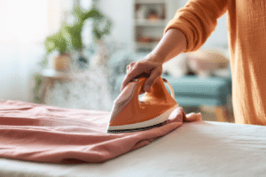 Visuel d'une personne repassant un tissus à l'aide d'un fer à repasser